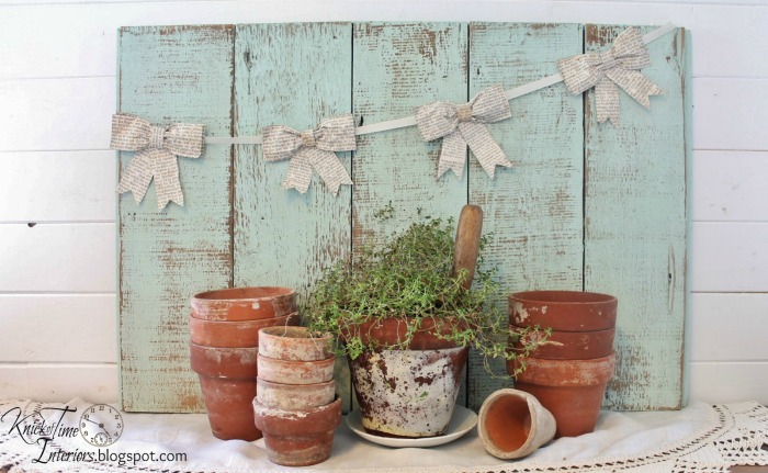 Old clay pots with rustic wodd backdrop and book page bows by Knick of Time | knickoftim.net