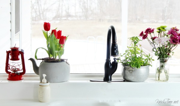 Put plants and flowers in repurposed pots, like an old kitchen coffee kettle, a cooking pot and a mason jar for a unique farmhouse flower display! - www.knickoftime.net
